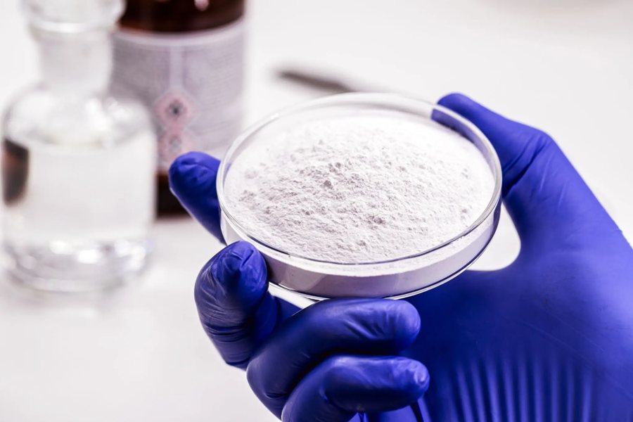 Pharmaceutical powder sample held in a gloved hand