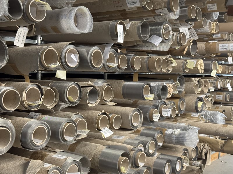 Racked inventory of woven wire mesh rolls