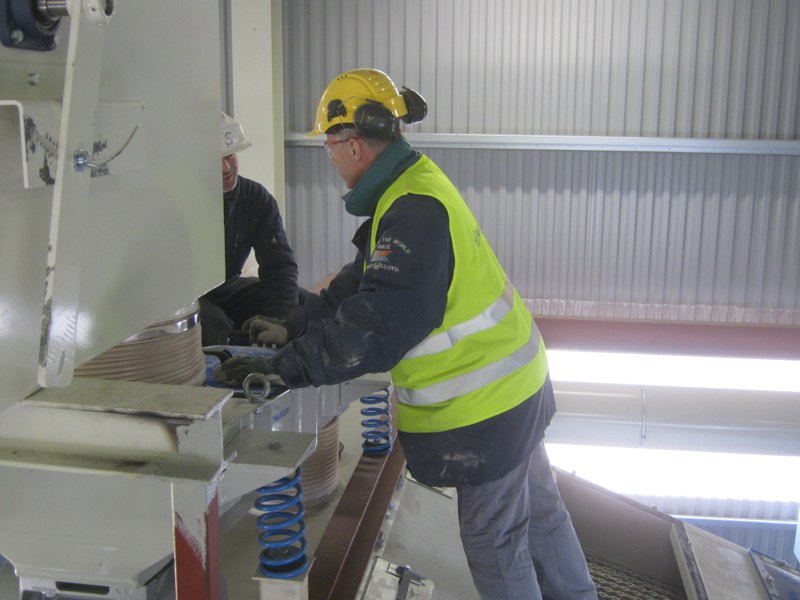 Technicians servicing a screening machine on site